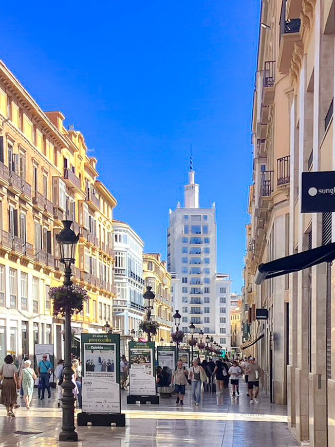 Calle comercial Marqués de Larios en mayo con el edificio Equitativa al fondo
