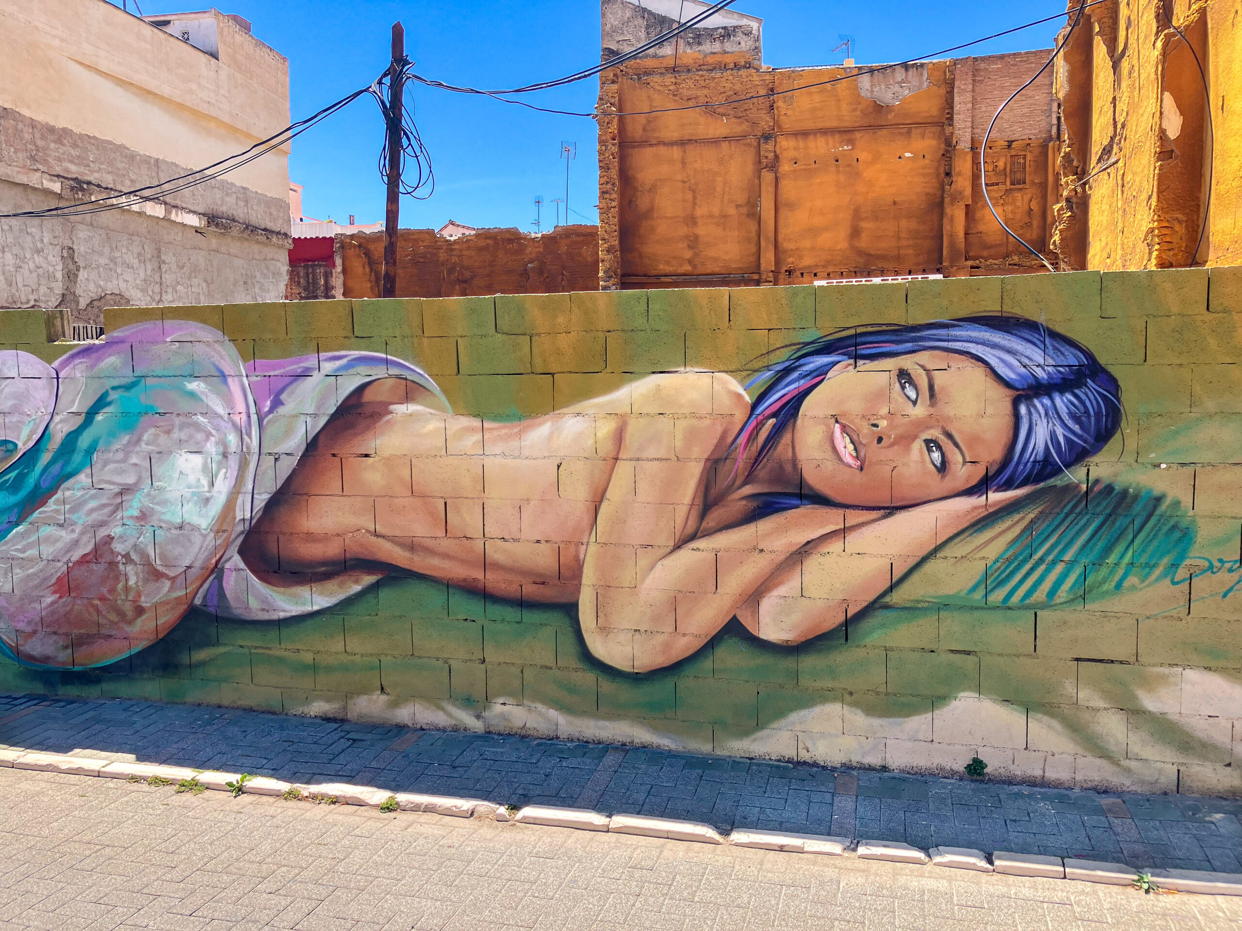 Street art depicting a sleeping girl in the city of Málaga, located in Plaza de la Aurora in the La Trinidad neighborhood, next to the Guadalmedina River
