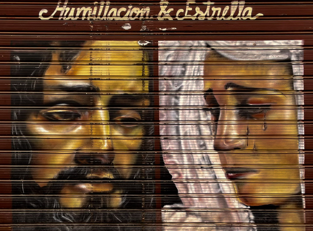 Jesus and Mary mural of Humillación y Estrella on a shop shutter in Málaga