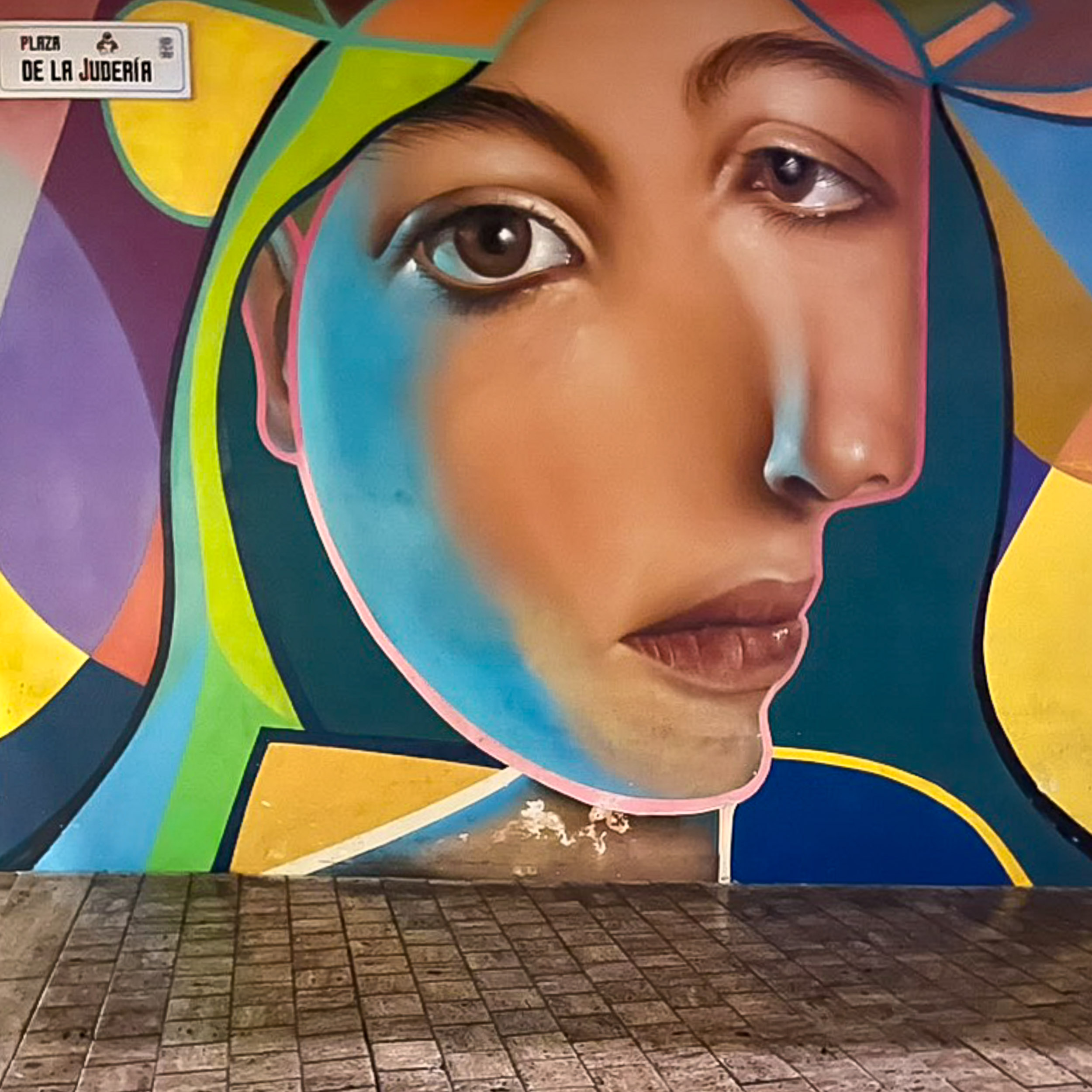Street art by Belin on Plaza de la Judería across the entrance of restaurant La Sole del Pimpi in the historic centre of Málaga