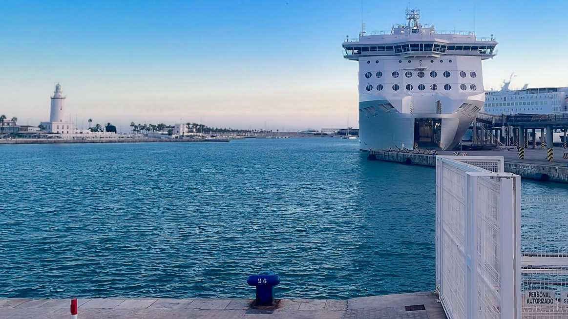 Crucero en el puerto de Málaga visto desde el Muelle Uno con el faro de La Farola al fondo