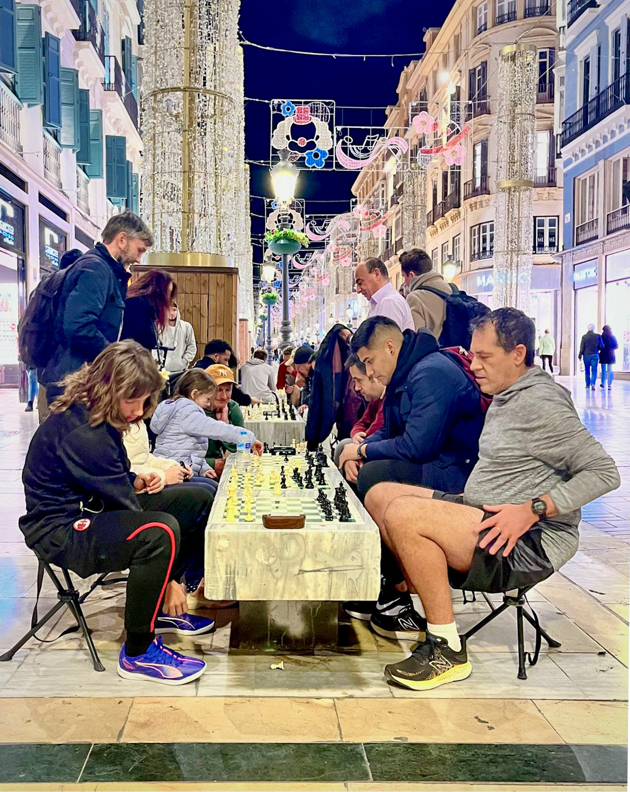 Calle Marqués de Larios, una calle comercial del casco antiguo de Málaga, con un grupo de personas jugando al ajedrez