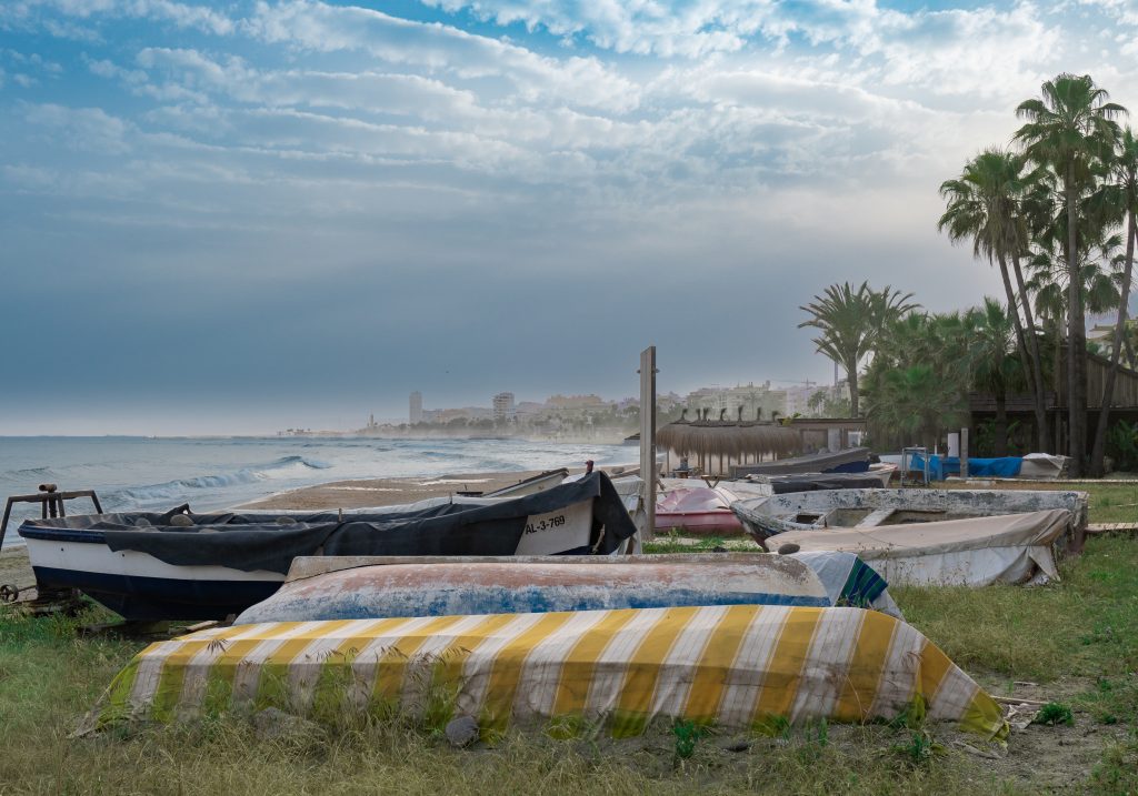 Barcas en la playa de Estepona, en la Costa del Sol, bajo un cielo nublado y dramático