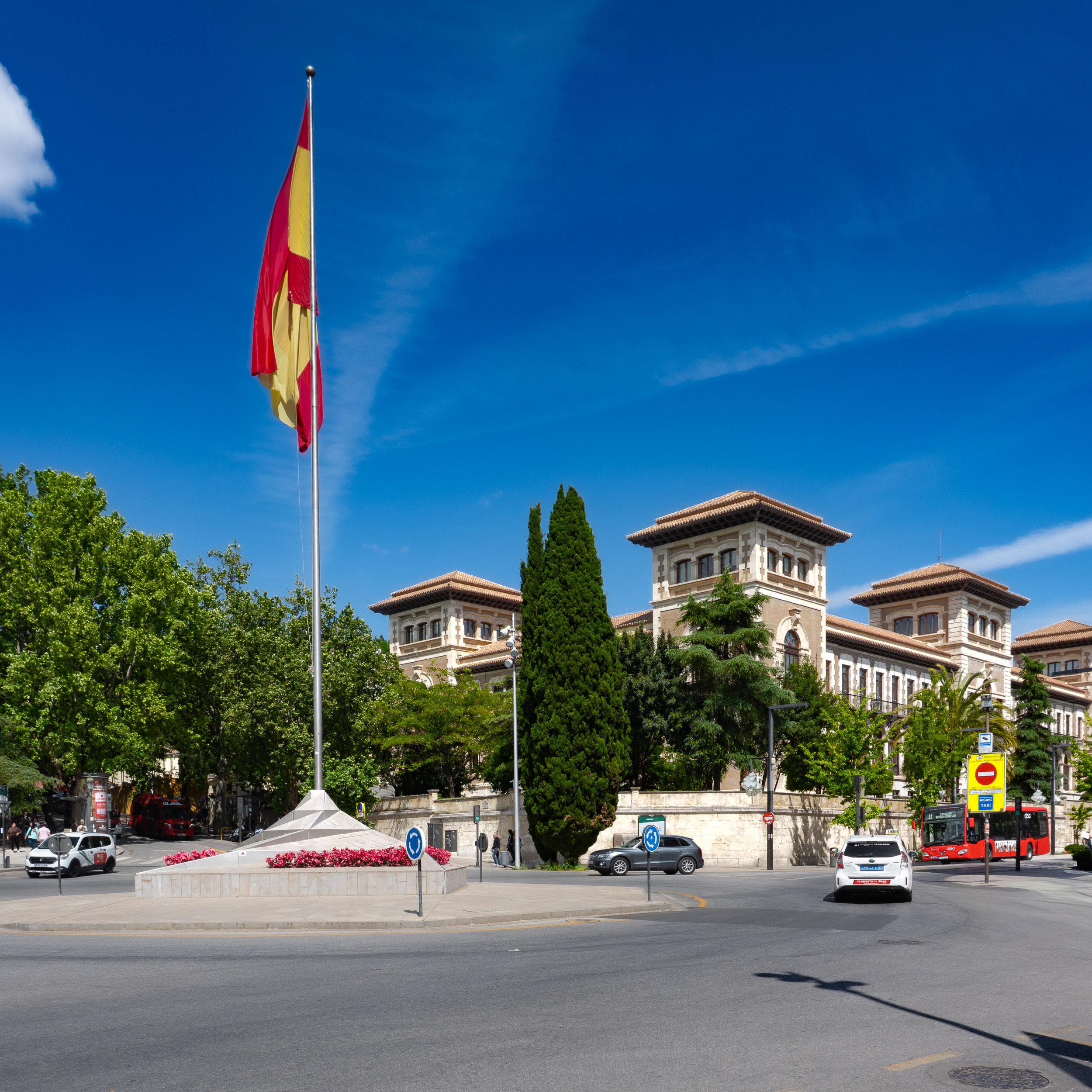 Roundabout with Spanish flag in Avenida de la Constitución in Granada with Delegación Territorial de Educación of Granada