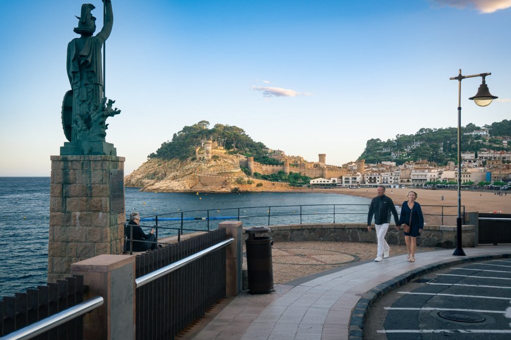 Estatua de Minerva (Frederic Marès)  y vista de la playa, el mar y las murallas del castillo de Tosa de Mar en Cataluña, Costa Brava