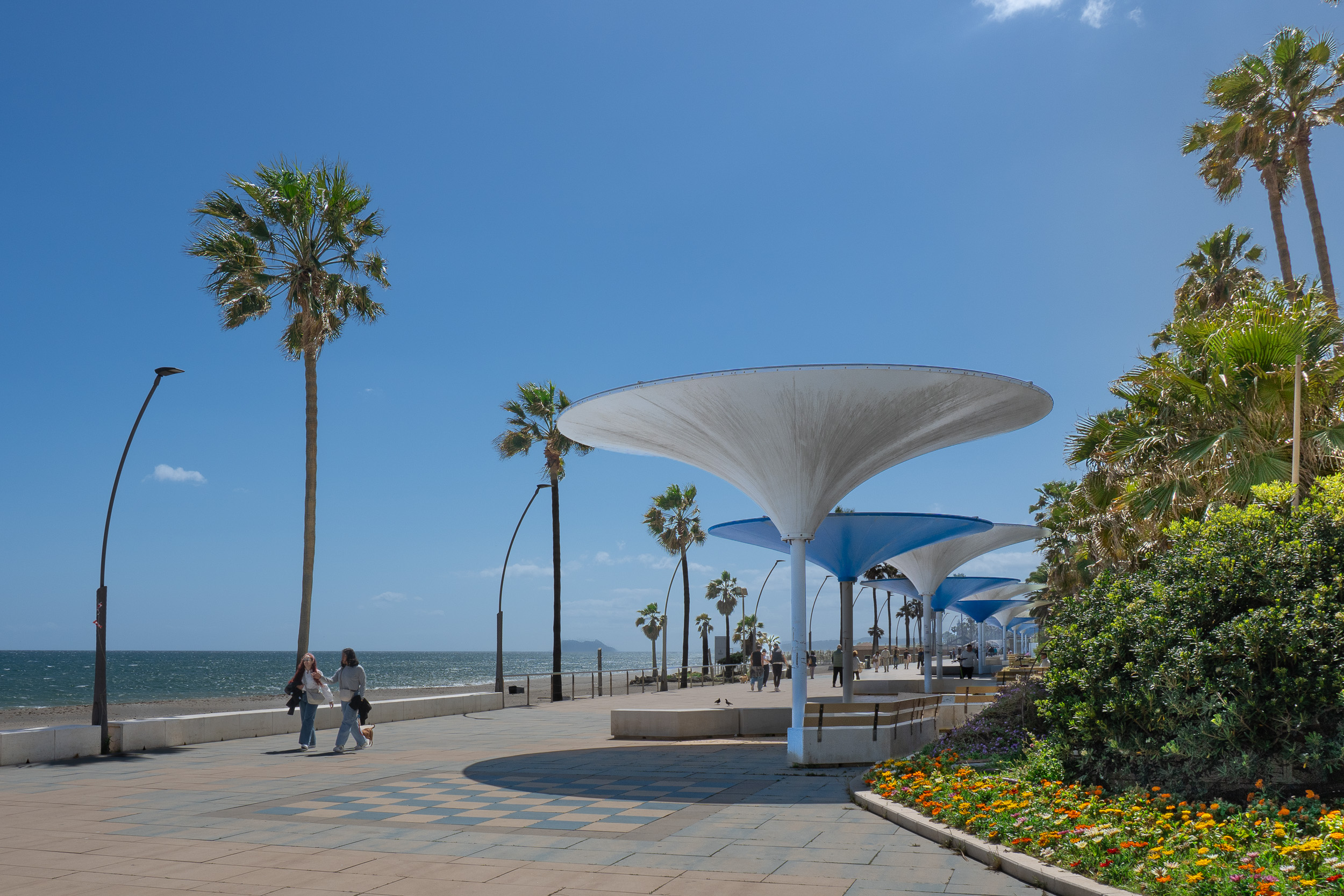 Paseo Marítimo seafront promenade in Estepona, next to the beach with beautiful plants and modern parasols