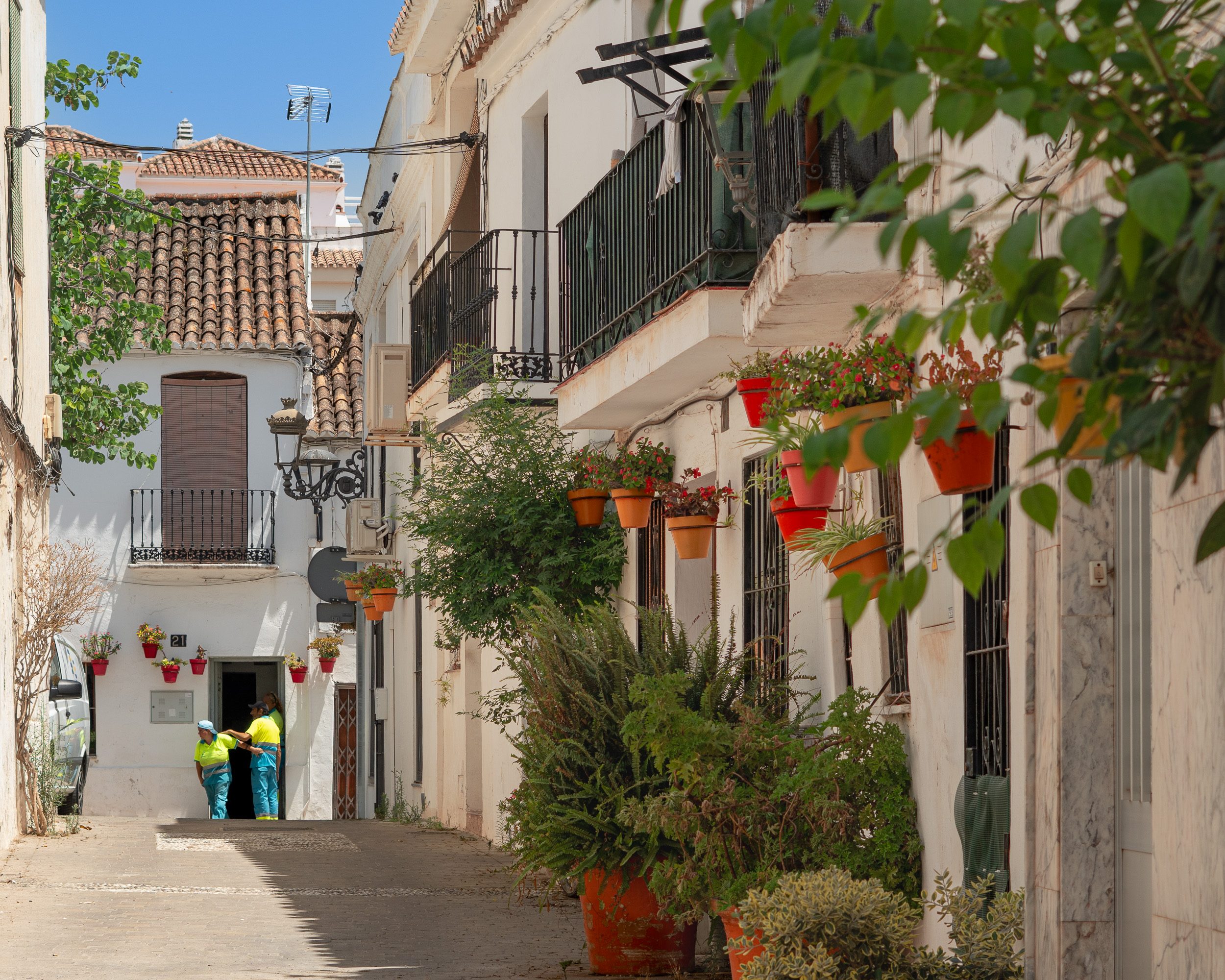 Flowers in wall-mounted pots decorating a whitewashed façade in Estepona