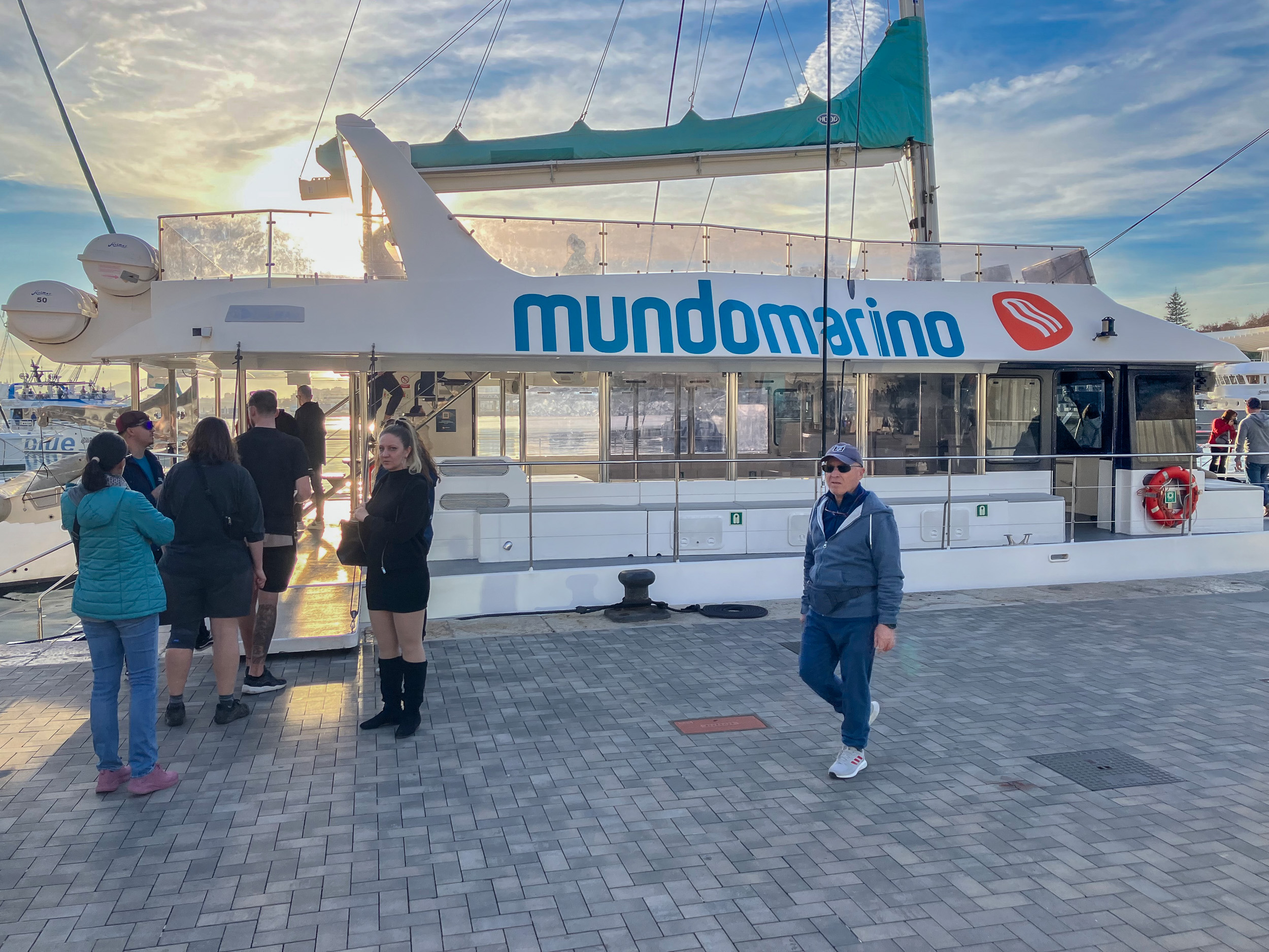 Catamarán Mundomarino saliendo desde Muelle Uno del puerto de Málaga al atardecer