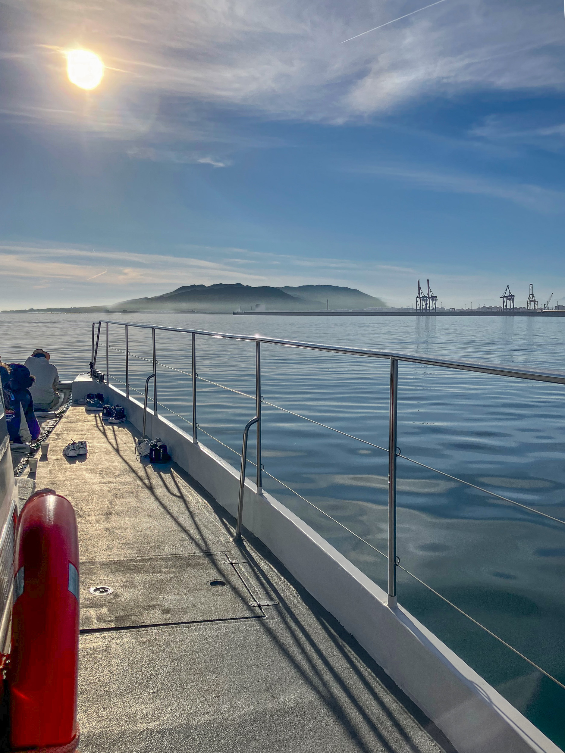 Vista del puerto de Málaga y de los Montes de Málaga desde un catamarán en el mar, saliendo desde Muelle Uno, al atardecer