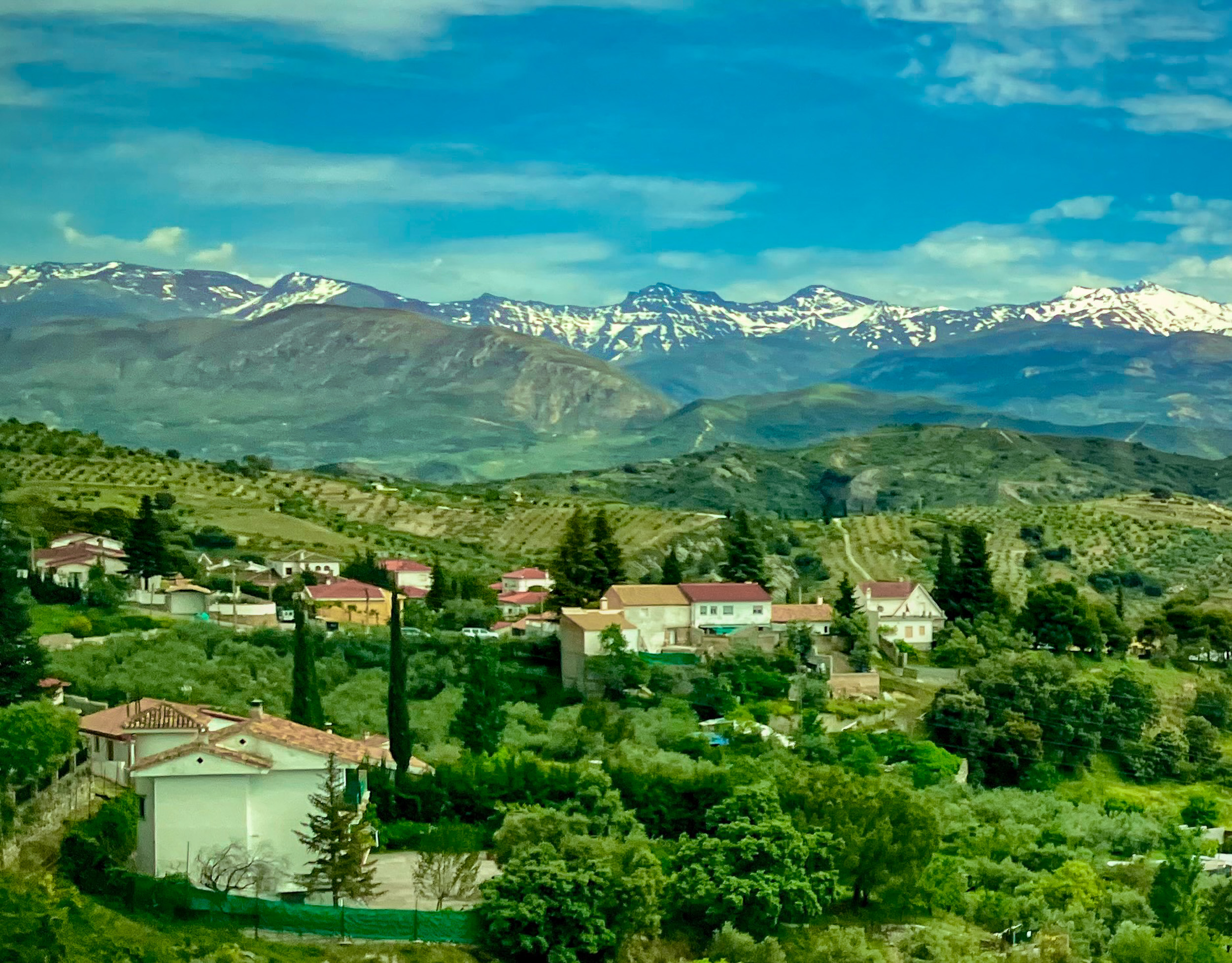 Pueblo en la Sierra Nevada con los picos Mulhacén y Veleta al fondo