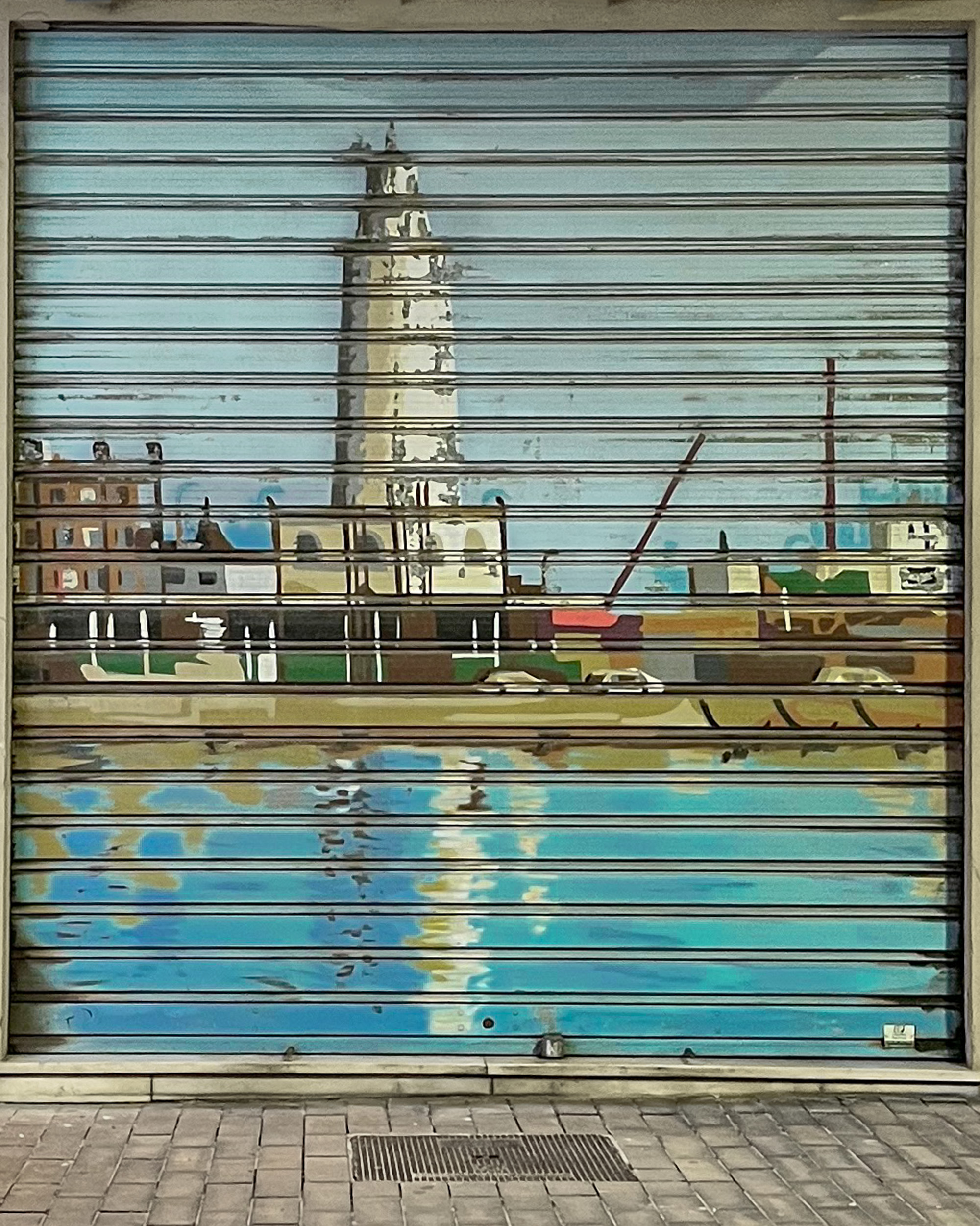 Below, you can see graffiti on the metal shutter of St. Martin’s barbershop depicting the "La Farola" lighthouse.
Graffiti on the metal shutter of St. Martin’s barbershop depicting the "La Farola" lighthouse. It is located on Calle Casa de Campos, in Málaga’s Soho