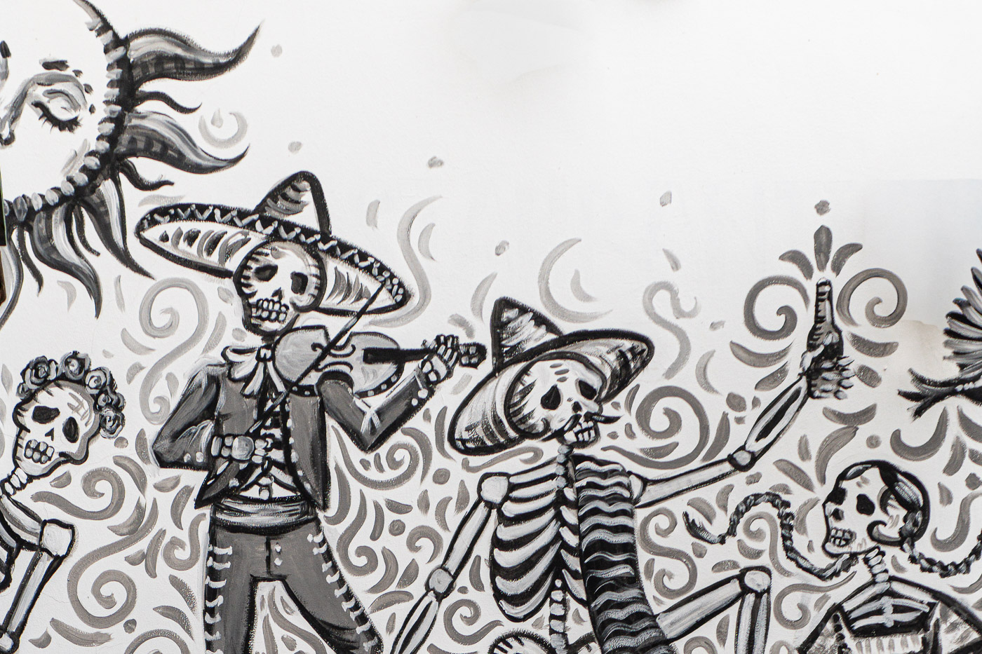 Detalle de un mural del artista callejero mexicano Val Rhoswen en el restaurante Mi México Comida Mexicana en la Calle Elvira en Granada, con esqueletos con sombreros