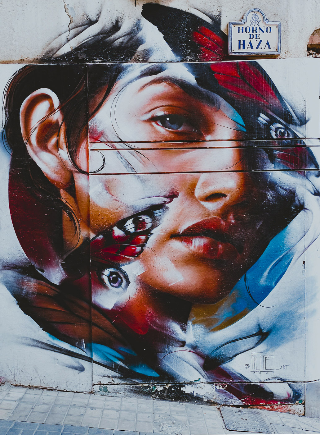 Mural del rostro de una mujer con mariposas, obra de Filite (2024), en la calle Horno de Haza de Granada