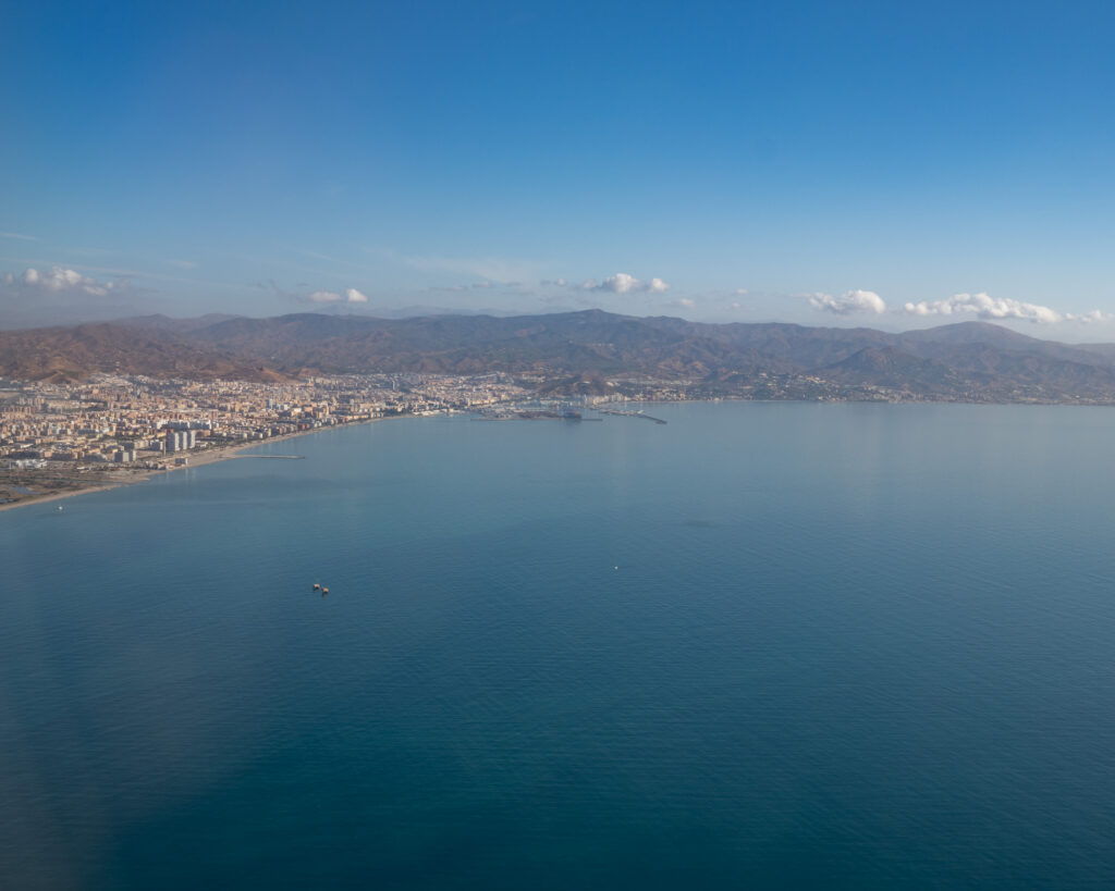 Vista aérea de Málaga, los Montes de Málaga, el mar, la costa y el puerto, tomada desde un avión