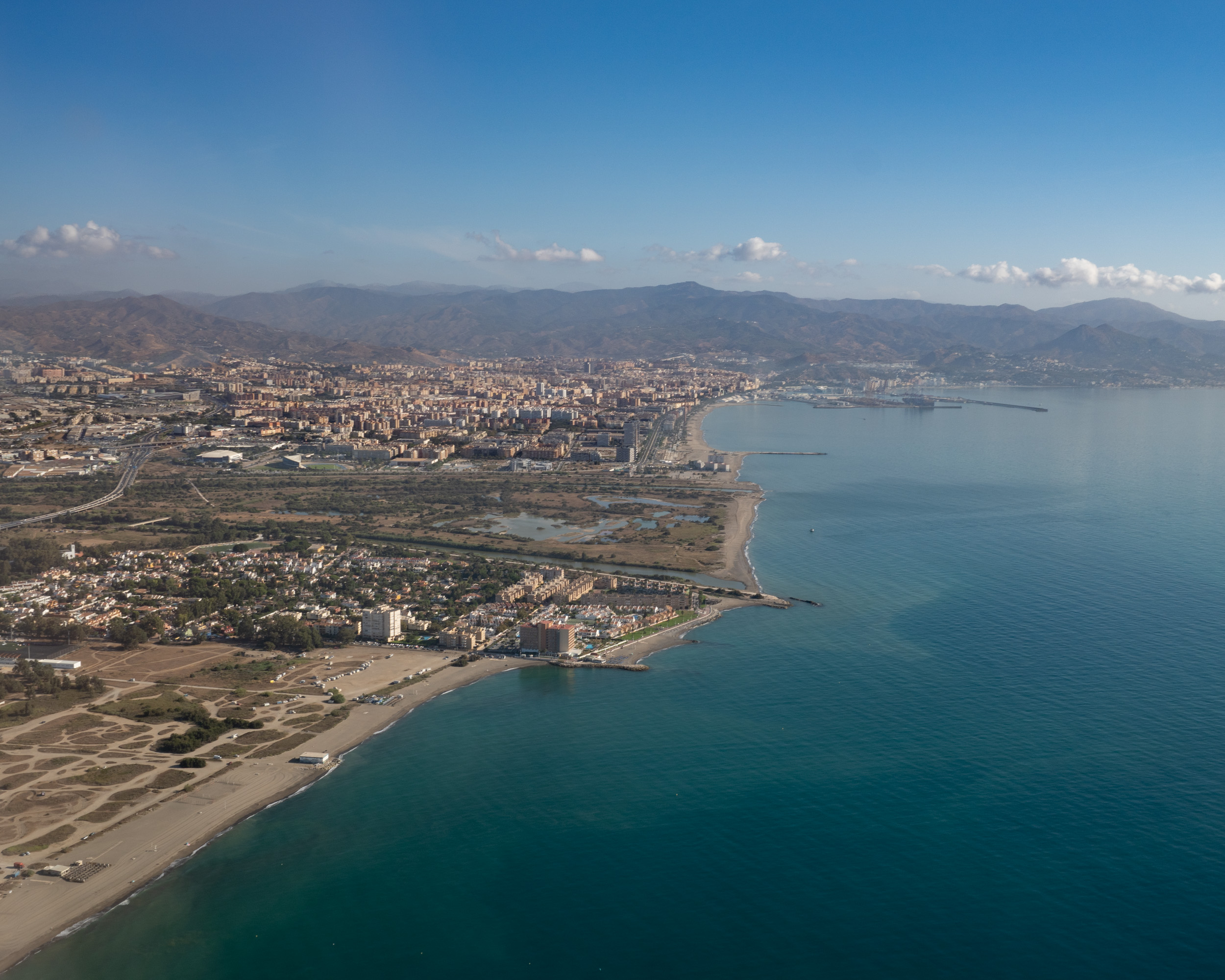 Vista aérea de la costa de Málaga, los Montes de Málaga, el mar y el puerto, tomada desde un avión